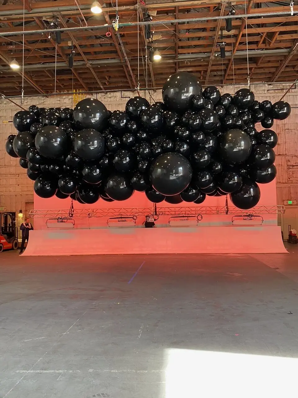Large-scale black balloon cloud sculpture suspended over stage for Super Bowl 2024 production — Amazing Balloons by Gee