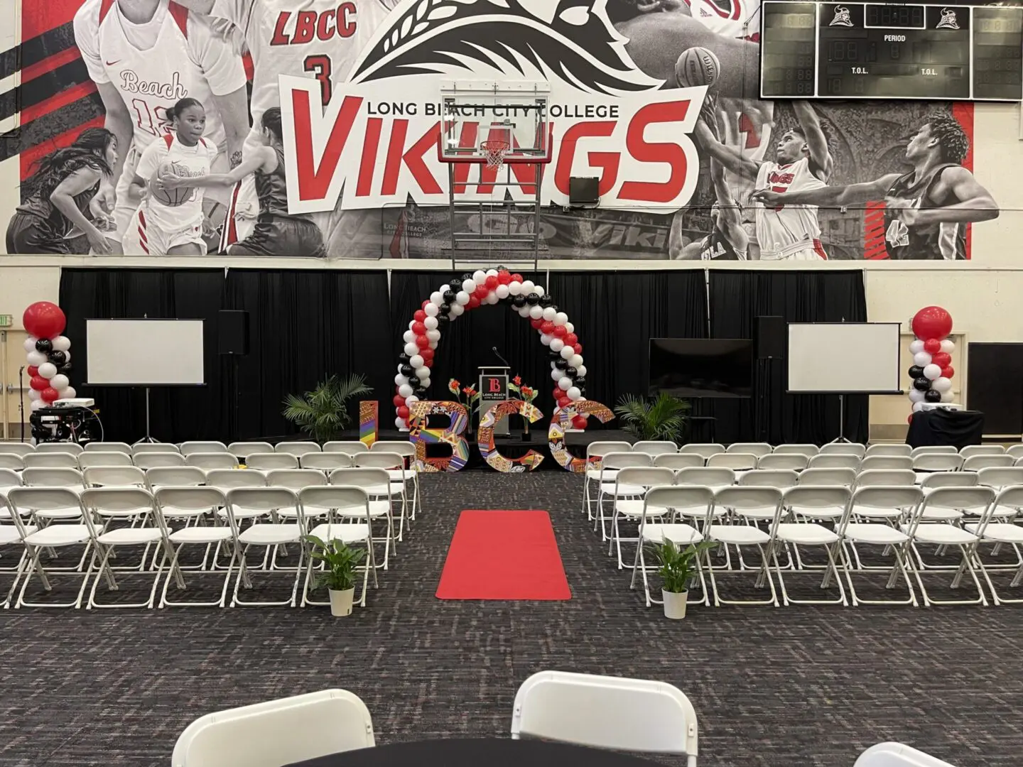 College gym ceremony setup with red carpet