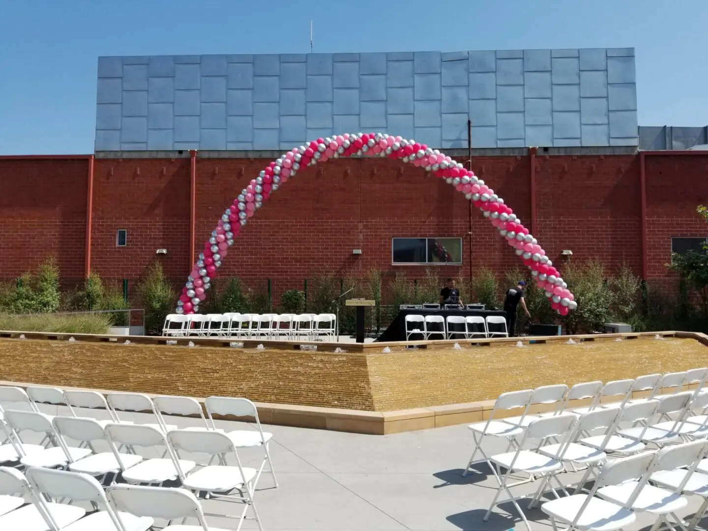 Outdoor ceremony with pink and white balloon arch