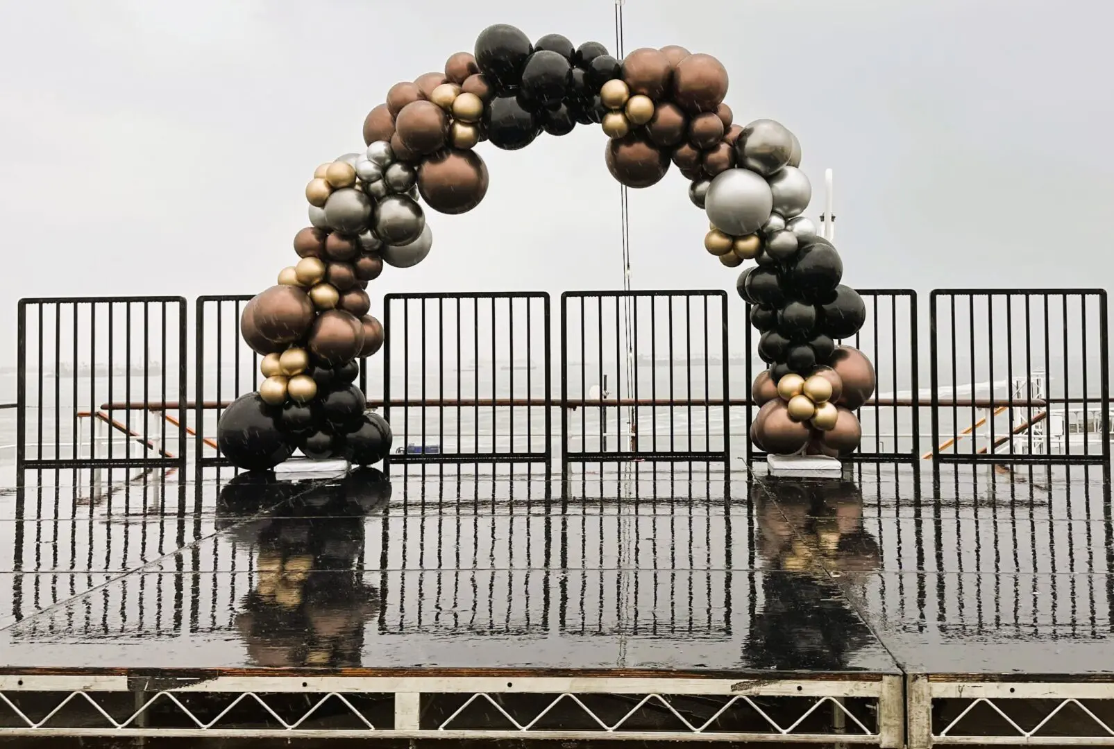 Metallic balloon arch on wet stage