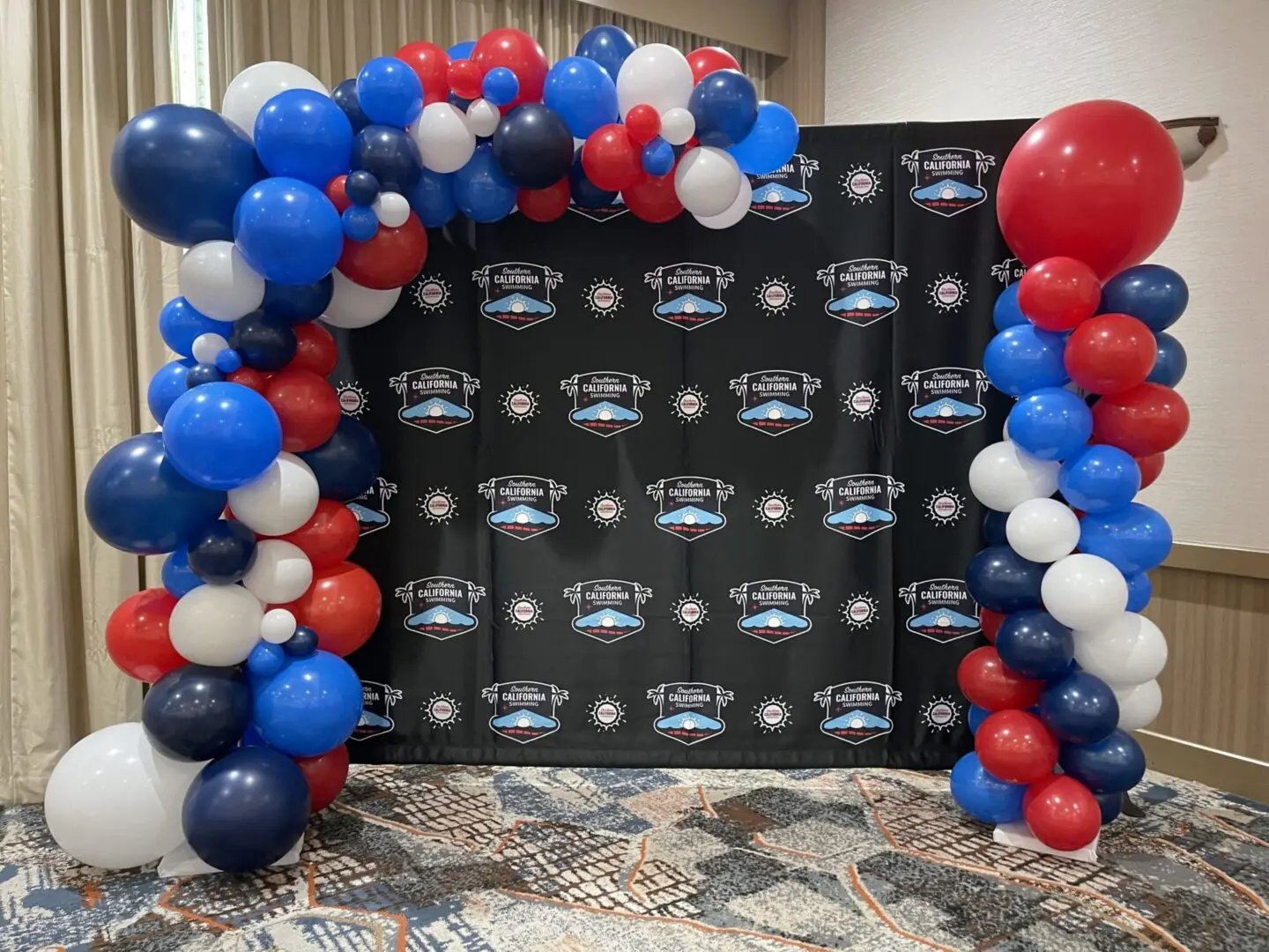 Red, white, and blue balloon arch backdrop