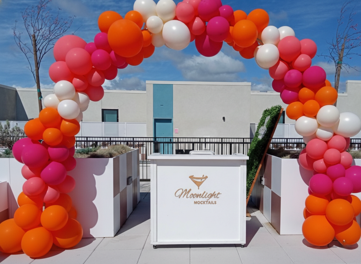 Colorful balloon arch over rooftop mocktail bar