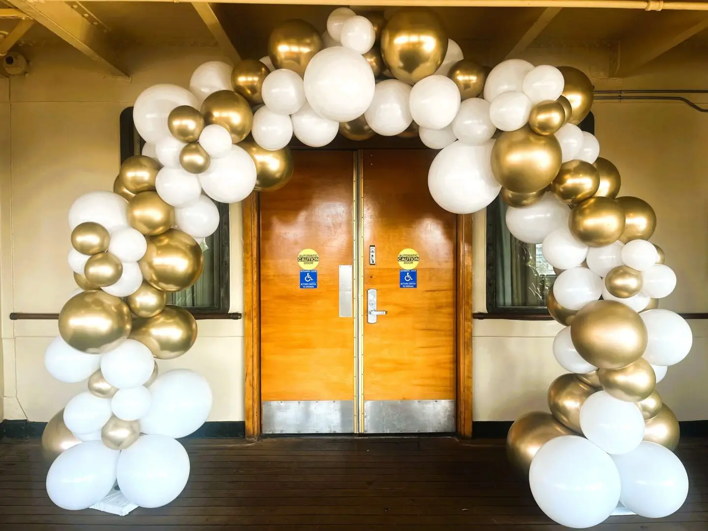 White and gold balloon arch at entrance