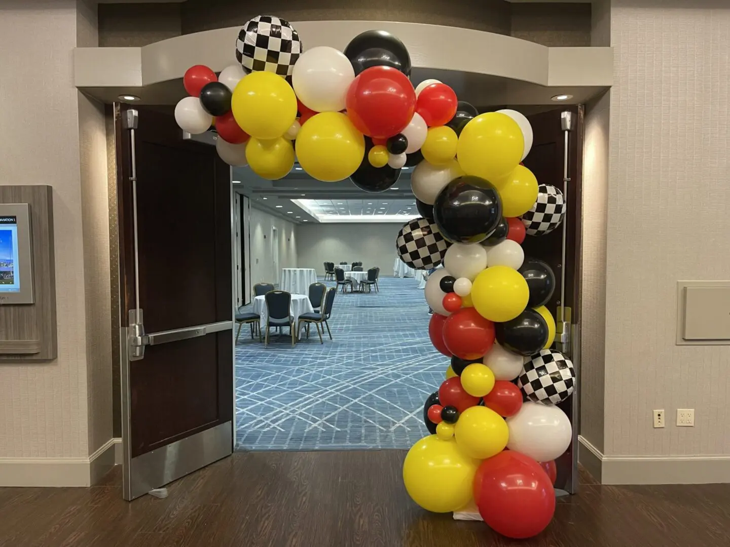 Red yellow black checkered balloon arch entrance