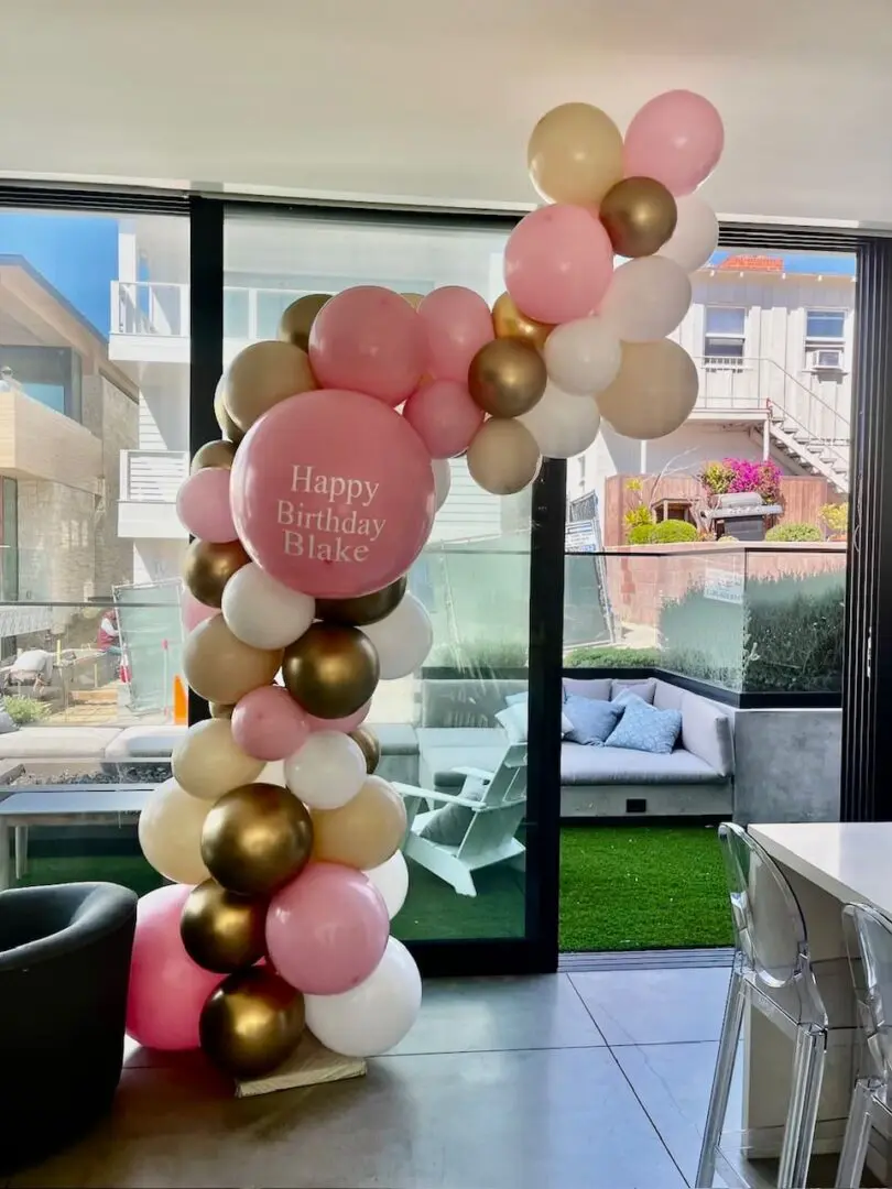 Pink, gold and white birthday balloon arch
