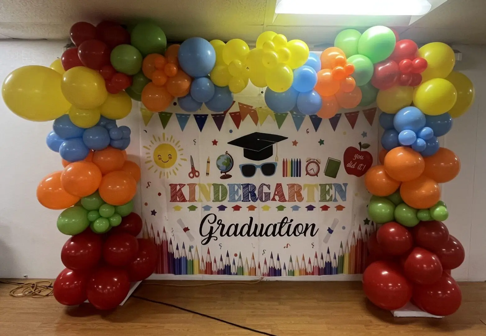 Colorful balloon arch and kindergarten graduation backdrop