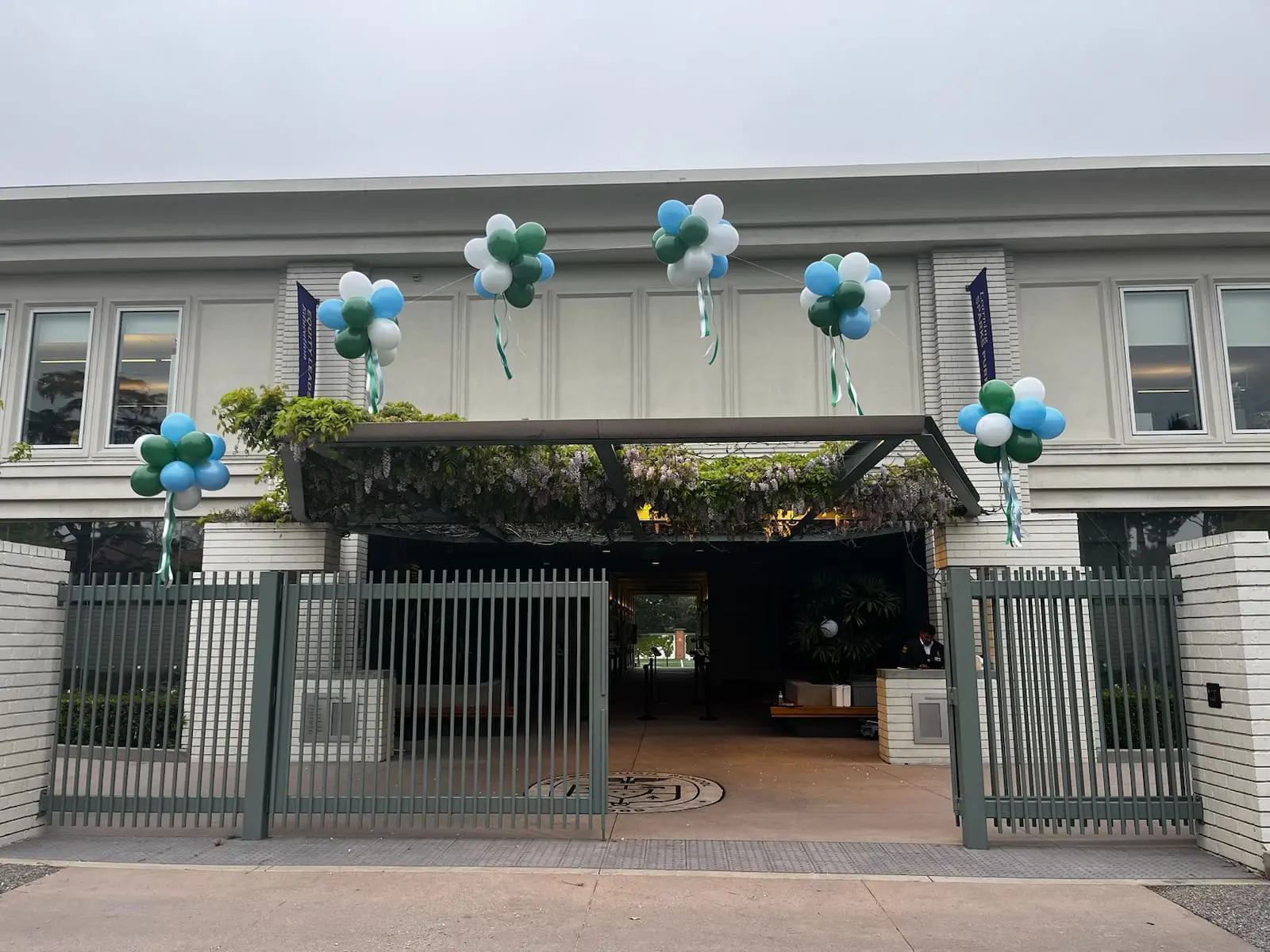 Gated entrance decorated with blue and green balloons
