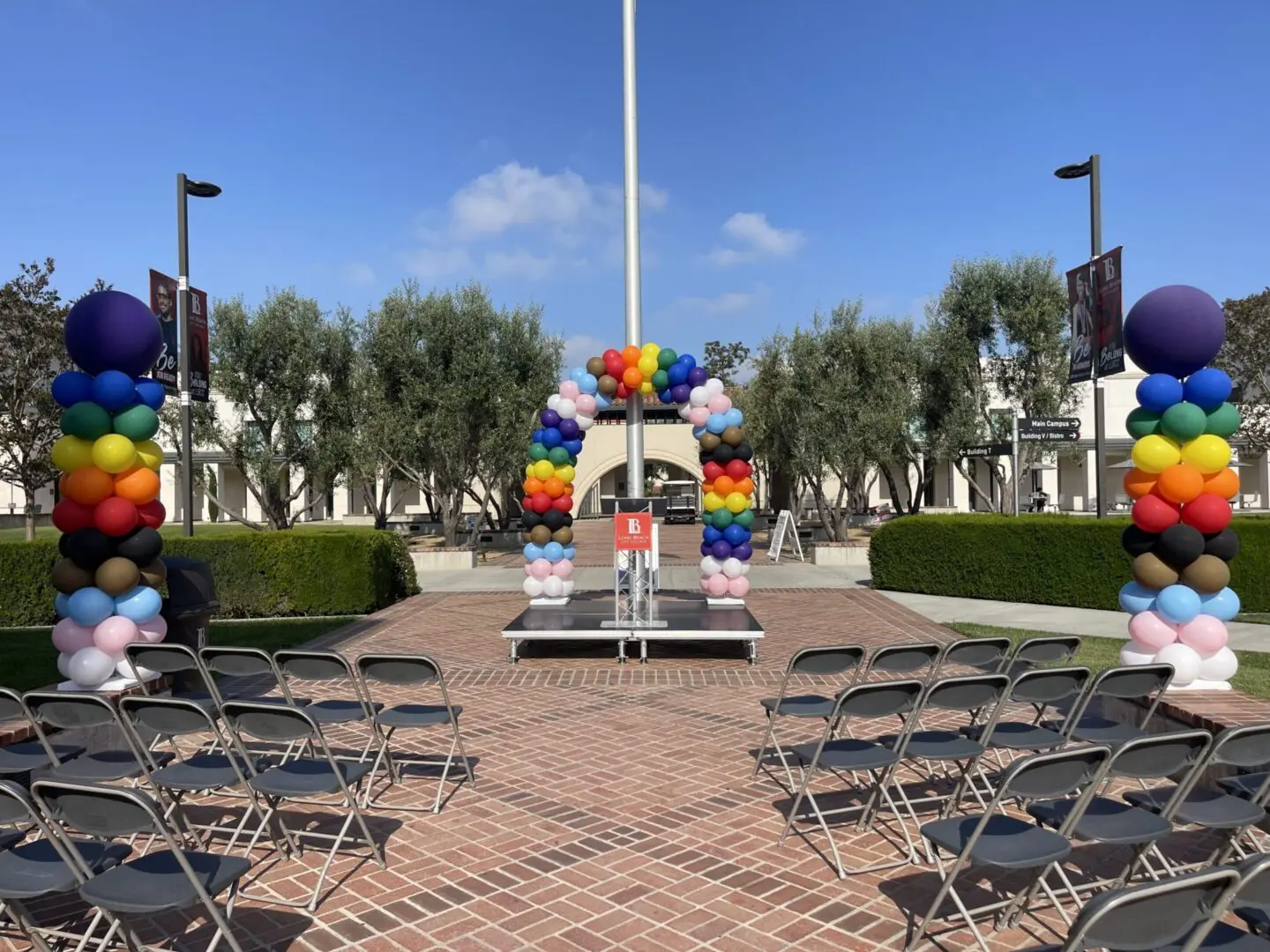 Outdoor ceremony setup with colorful balloon arch