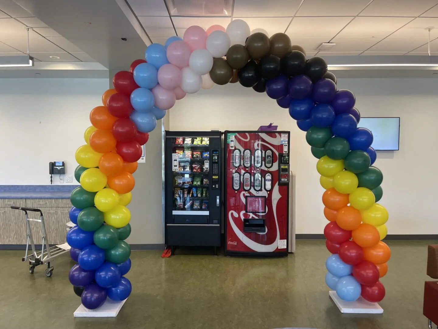 Rainbow balloon arch in front of vending machines