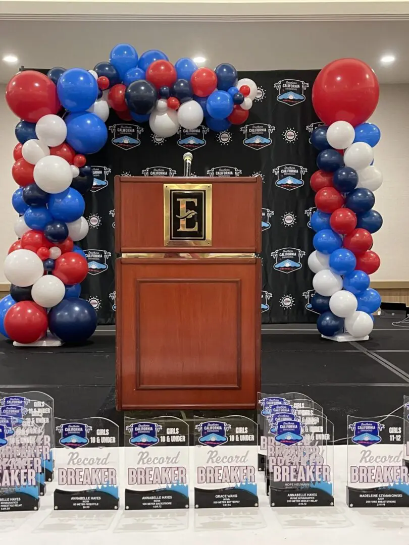 Podium with balloon arch and record breaker trophies