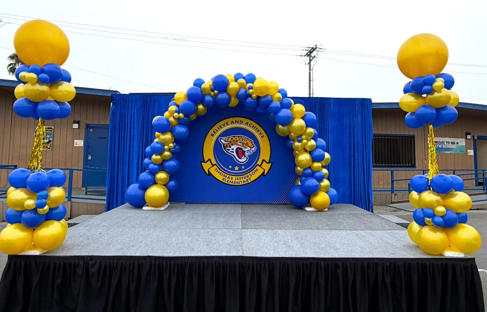 Blue and yellow balloon arch on stage