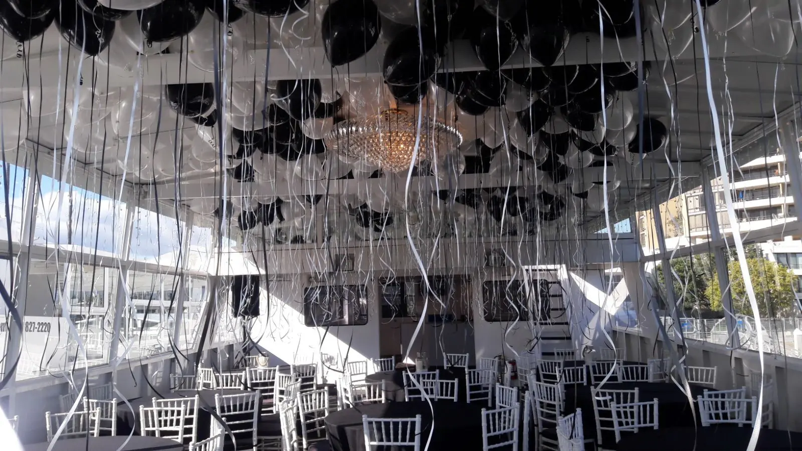 Balloon filled event tent with white chairs