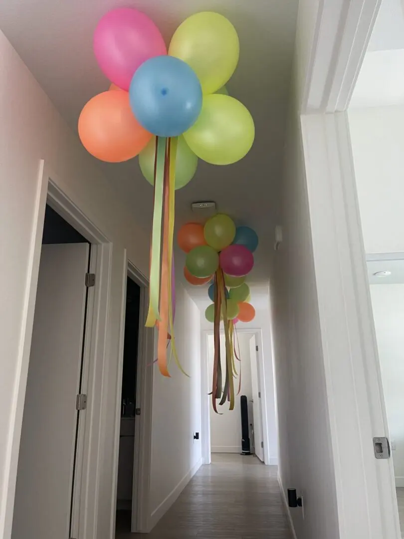Colorful balloon clusters with hanging ribbons
