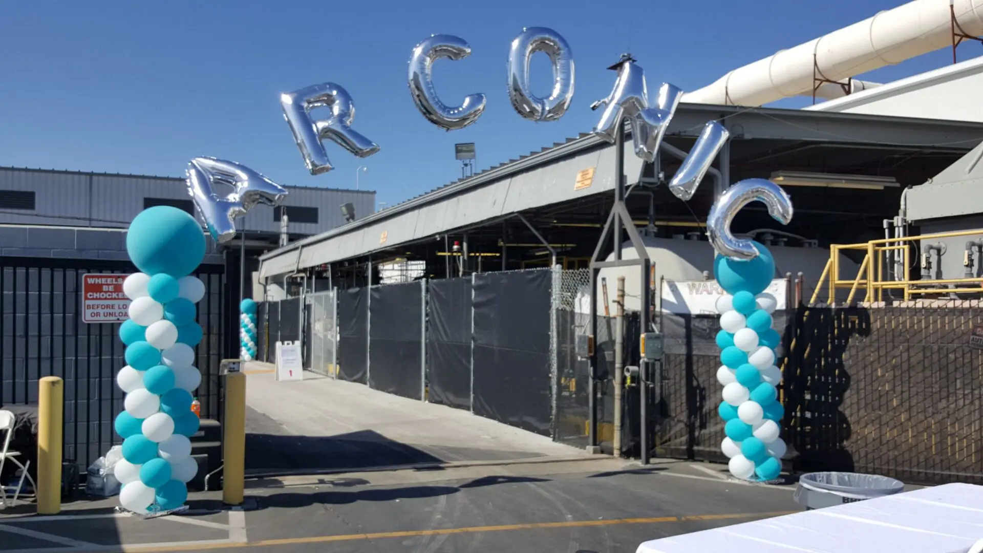Industrial facility entrance with teal balloon arch