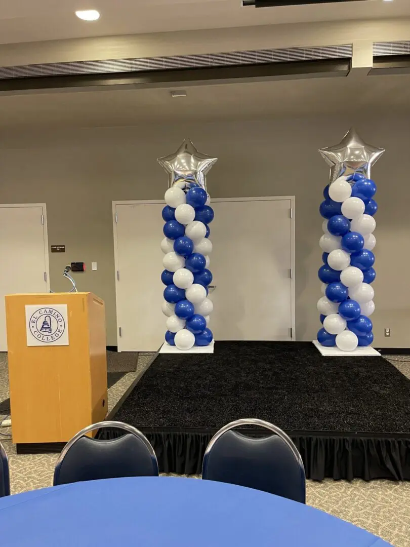 Stage with blue-and-white balloon columns and podium