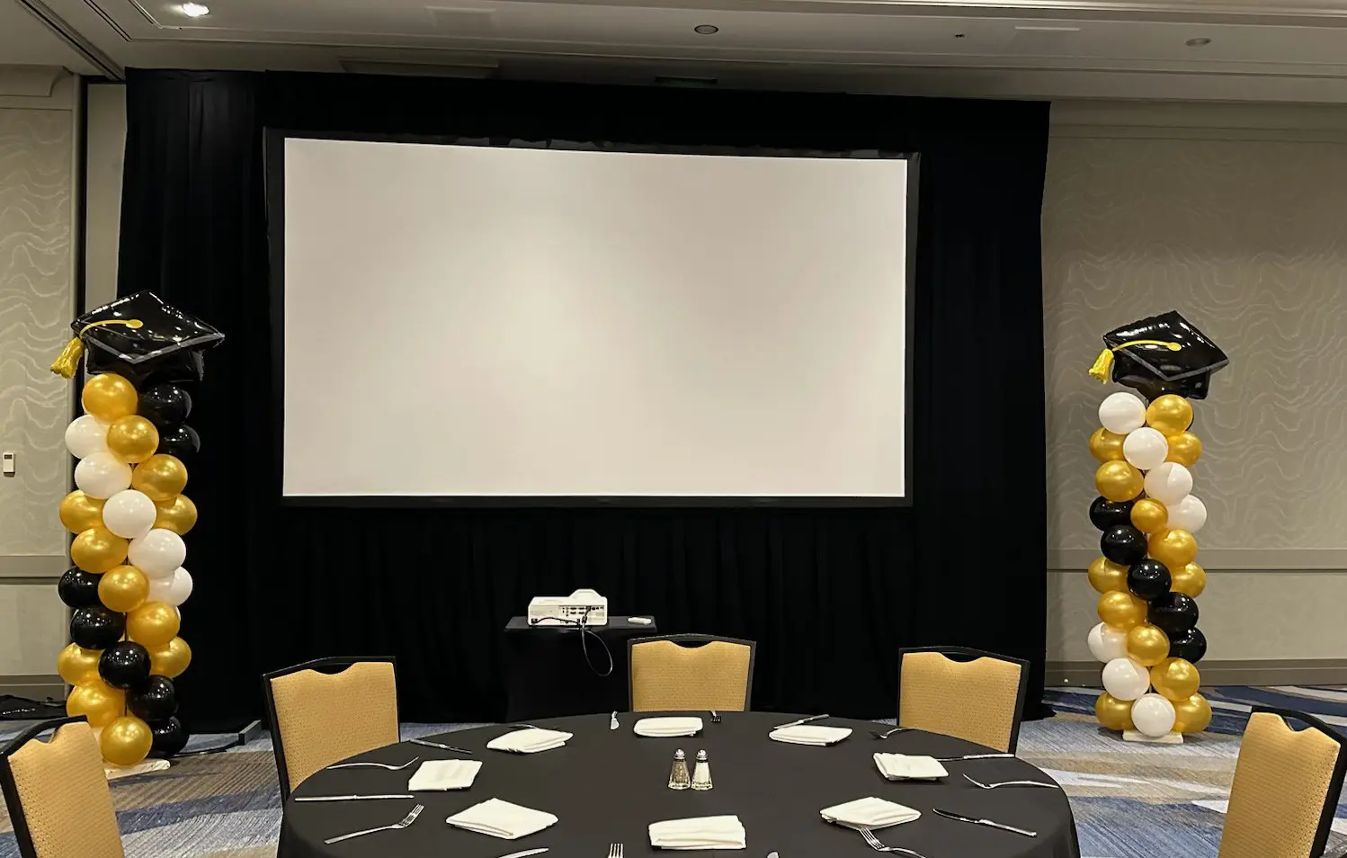 Graduation banquet room with screen and balloons