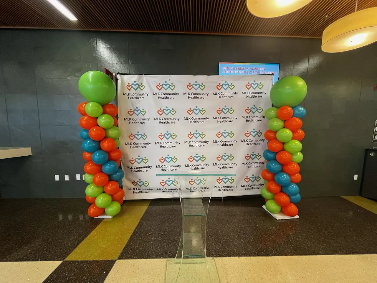 Event backdrop with colorful balloon columns and podium