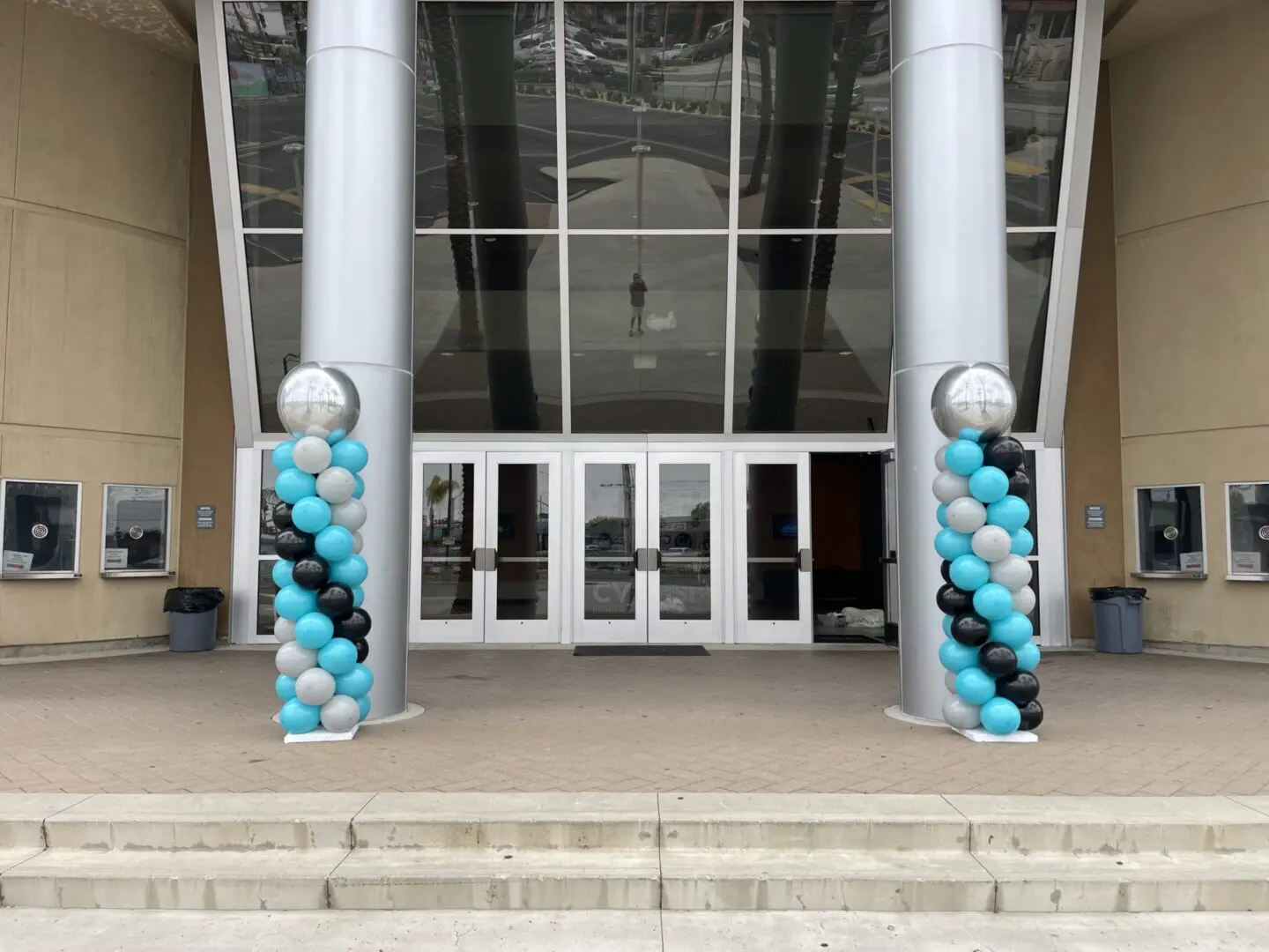 Building entrance with teal white black balloon columns