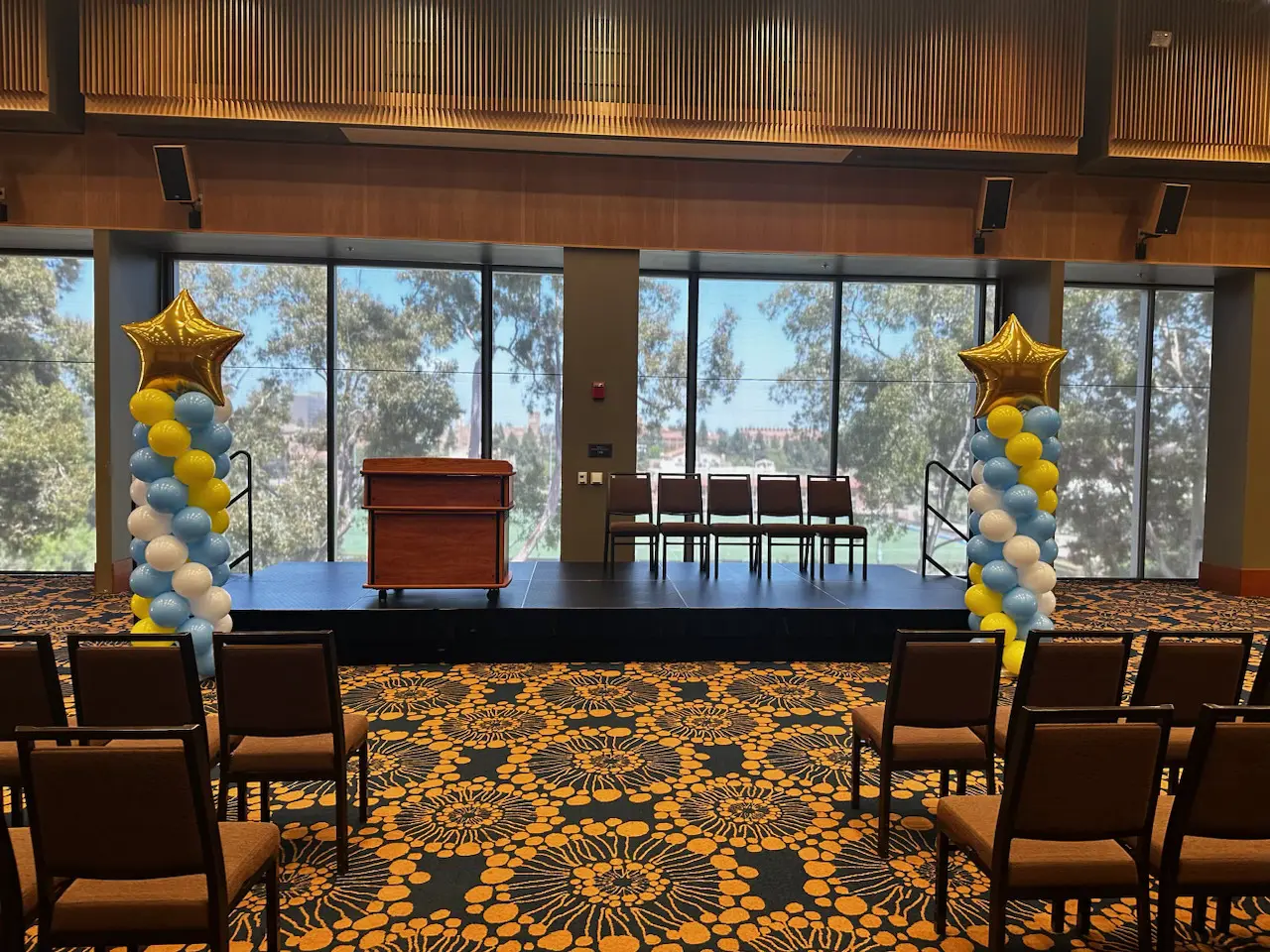Stage with podium and star-topped balloon columns