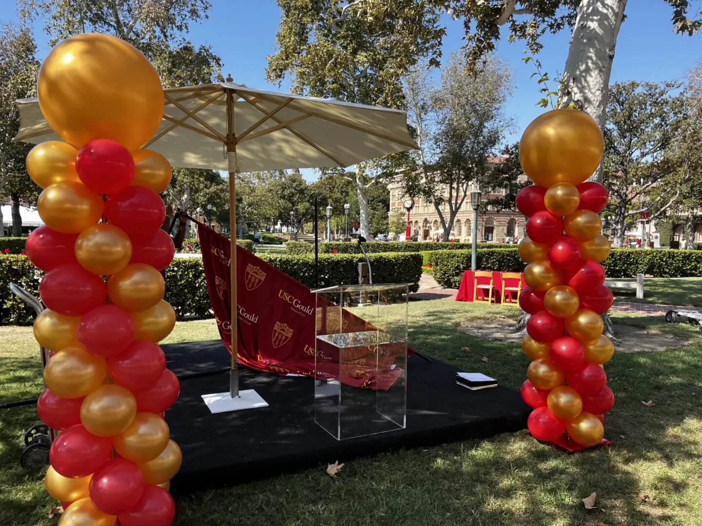 Outdoor podium with red and gold balloons