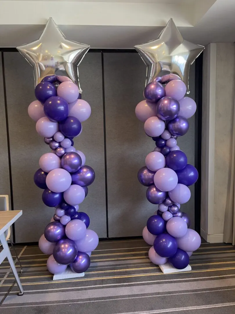 Two purple balloon columns with silver stars