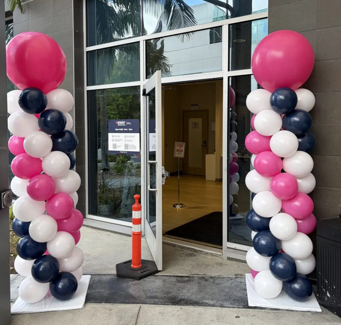 Entrance flanked by pink, white, navy balloon columns