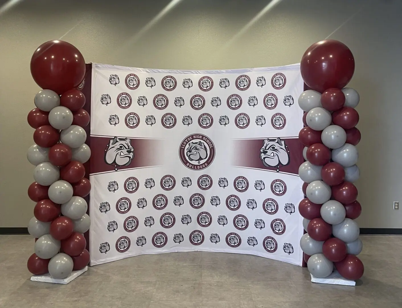 Maroon and gray balloon columns with bulldog backdrop