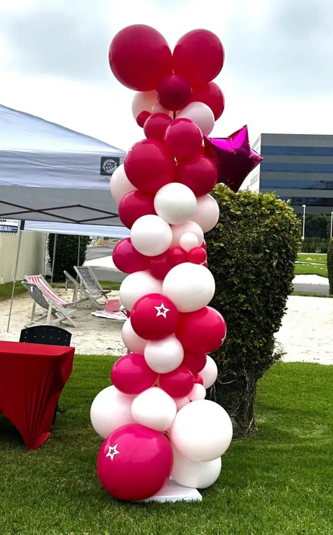 Pink and white balloon column at outdoor event