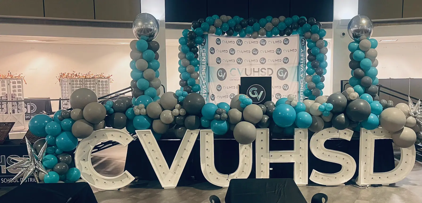 Teal gray balloon arch with illuminated CVUHSD letters