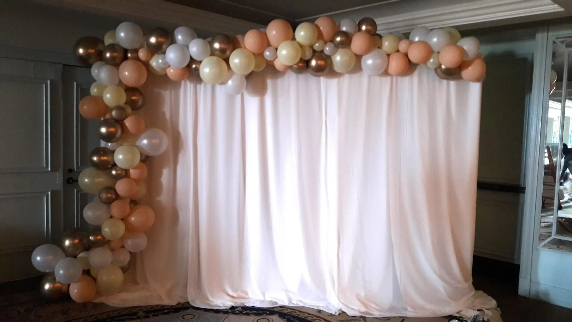 Peach and gold balloon backdrop with drape