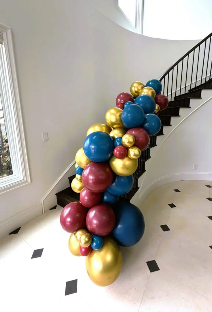 Blue, gold, burgundy balloon garland on staircase