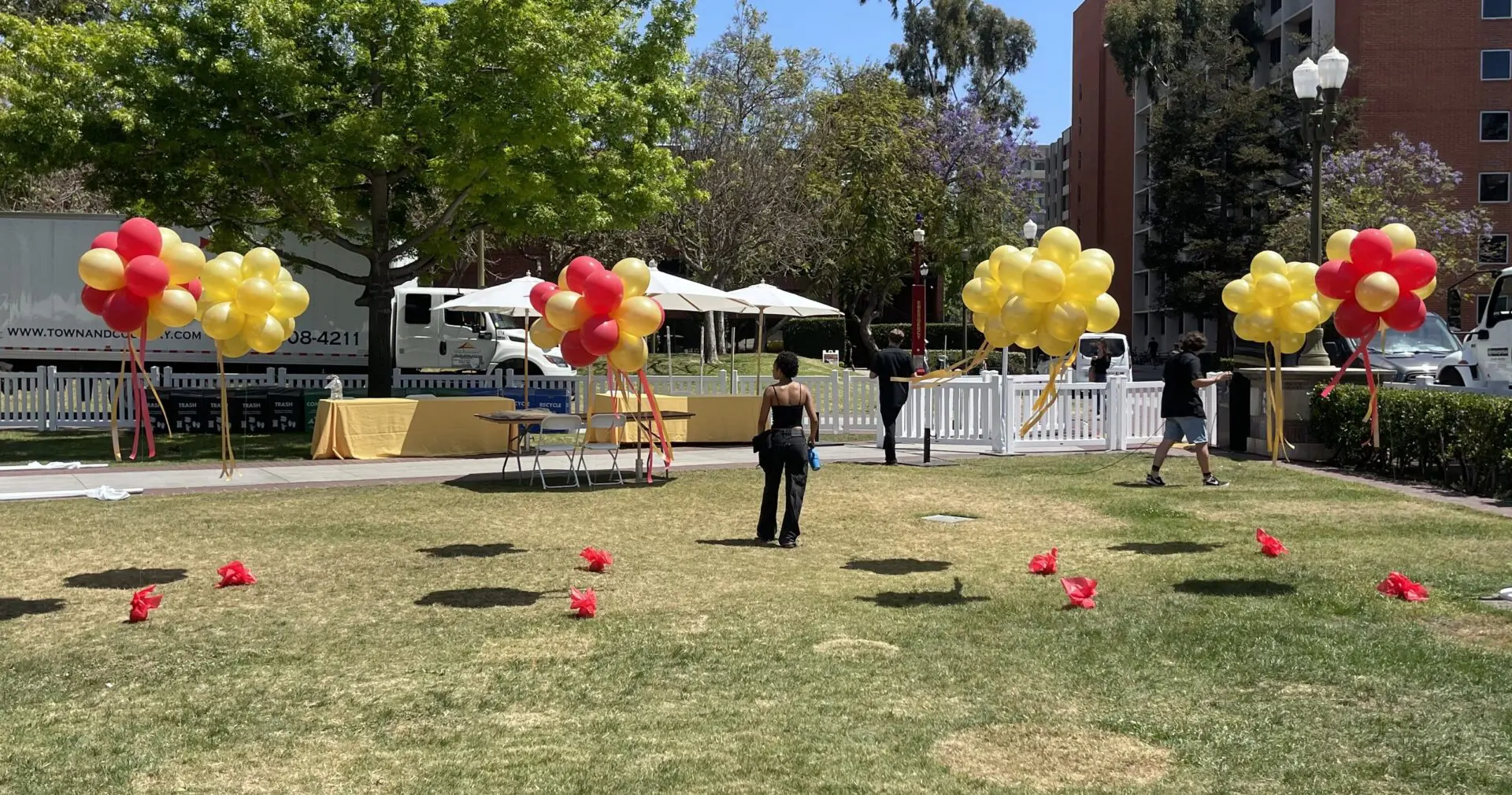 Outdoor event setup with red and yellow balloons
